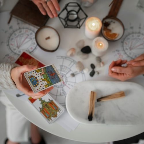 Vista superior de mulher lendo tarot com velas